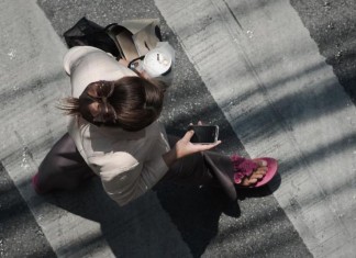 Une femme consulte son smartphone dans la rue